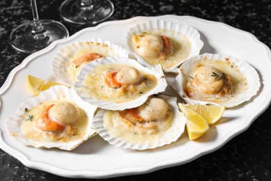 Photo of Fried scallops in shells on black table, closeup