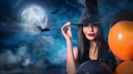 Image of Witch with balloons and full moon in misty sky on Halloween