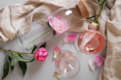 Photo of Flat lay composition with rose wine and beautiful pink peonies on white background