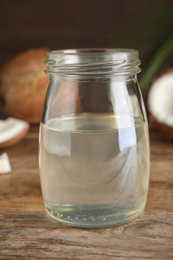 Photo of Coconut oil on wooden table, closeup view