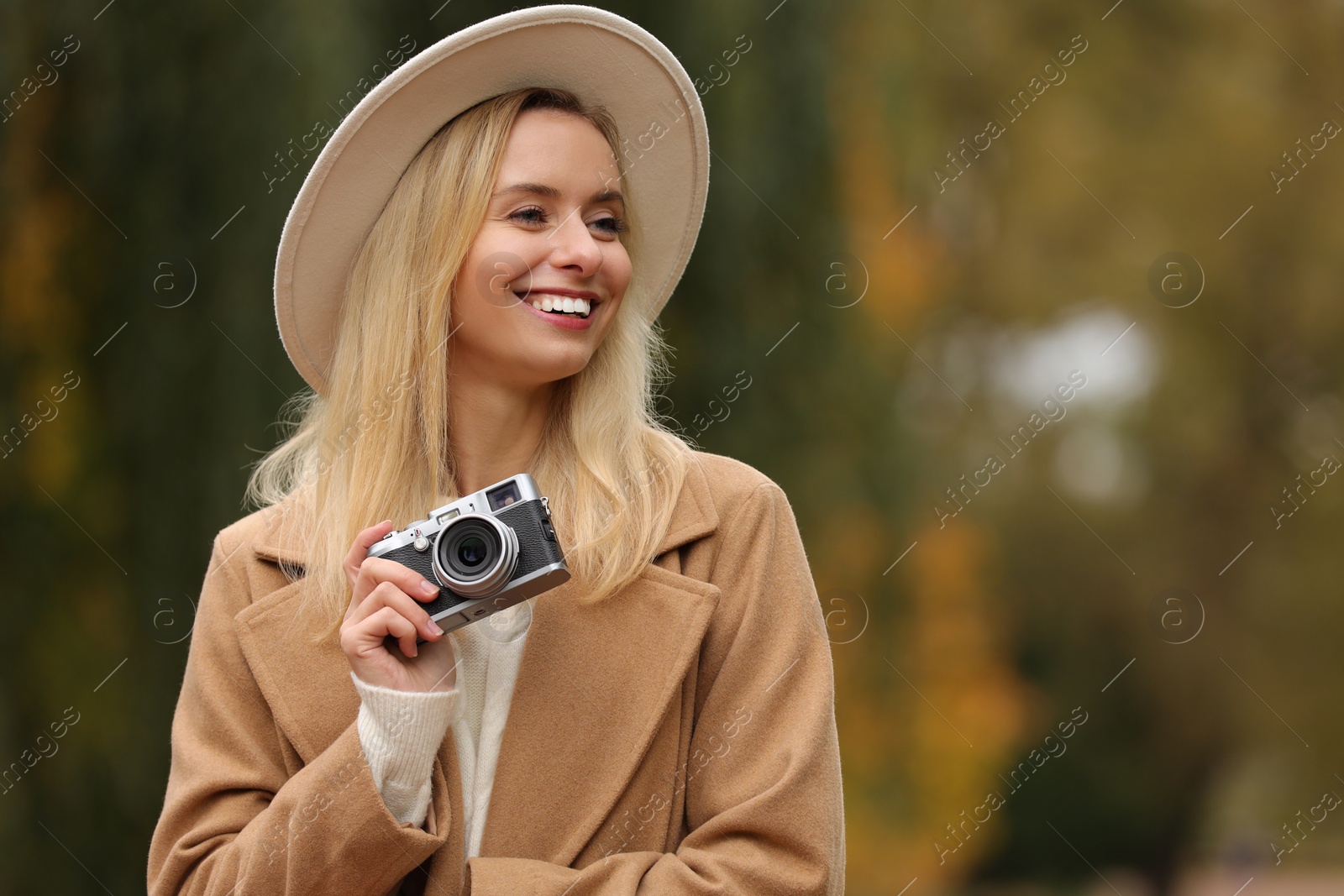 Photo of Autumn vibes. Portrait of happy woman with camera outdoors, space for text