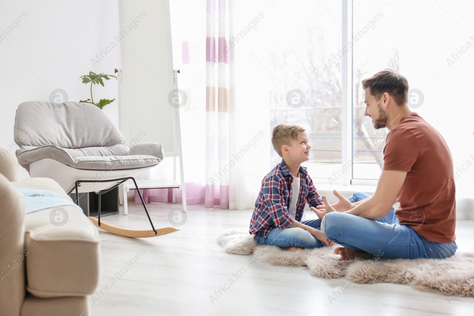 Photo of Little boy and his dad spending time together at home