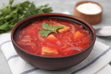 Bowl of delicious borscht on table, closeup