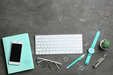 Photo of Blogger's workplace with smartphone, keyboard and accessories on grey table, top view. Space for text