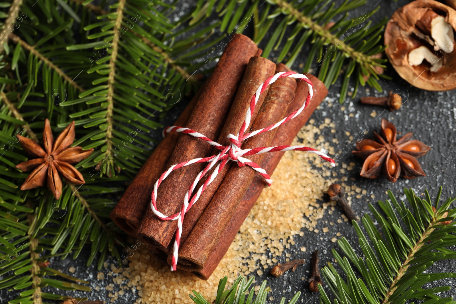 Photo of Different aromatic spices and fir branches on grey textured table, flat lay