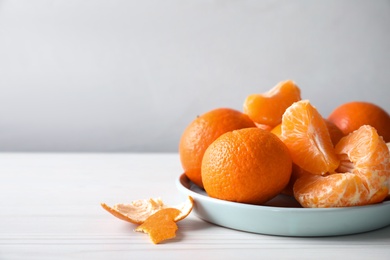 Photo of Delicious fresh ripe tangerines on white table. Space for text