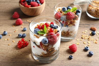 Image of Tasty dessert with yogurt, berries and granola on wooden table