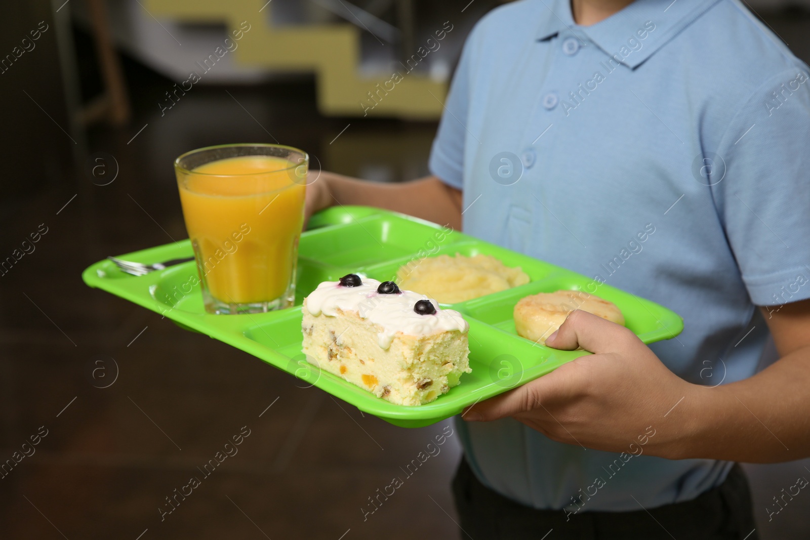 Photo of Boy holding tray with healthy food in school canteen, closeup