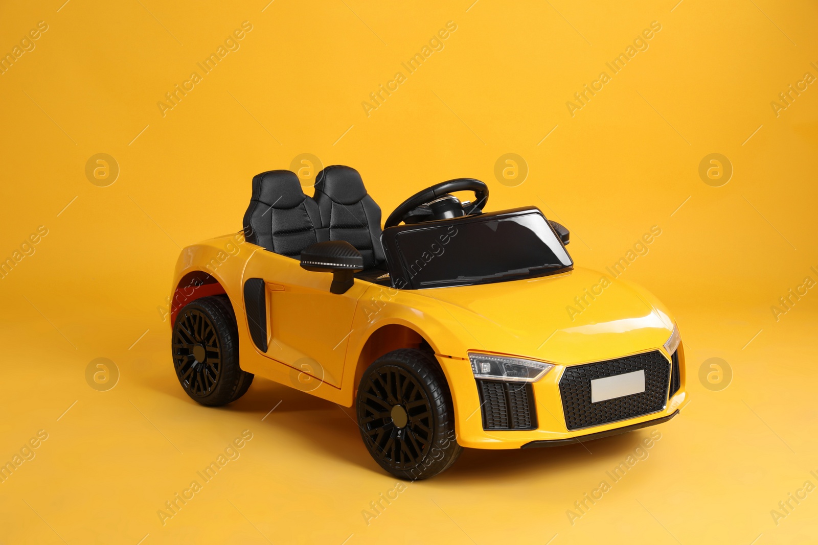 Photo of New bright toy car on yellow background