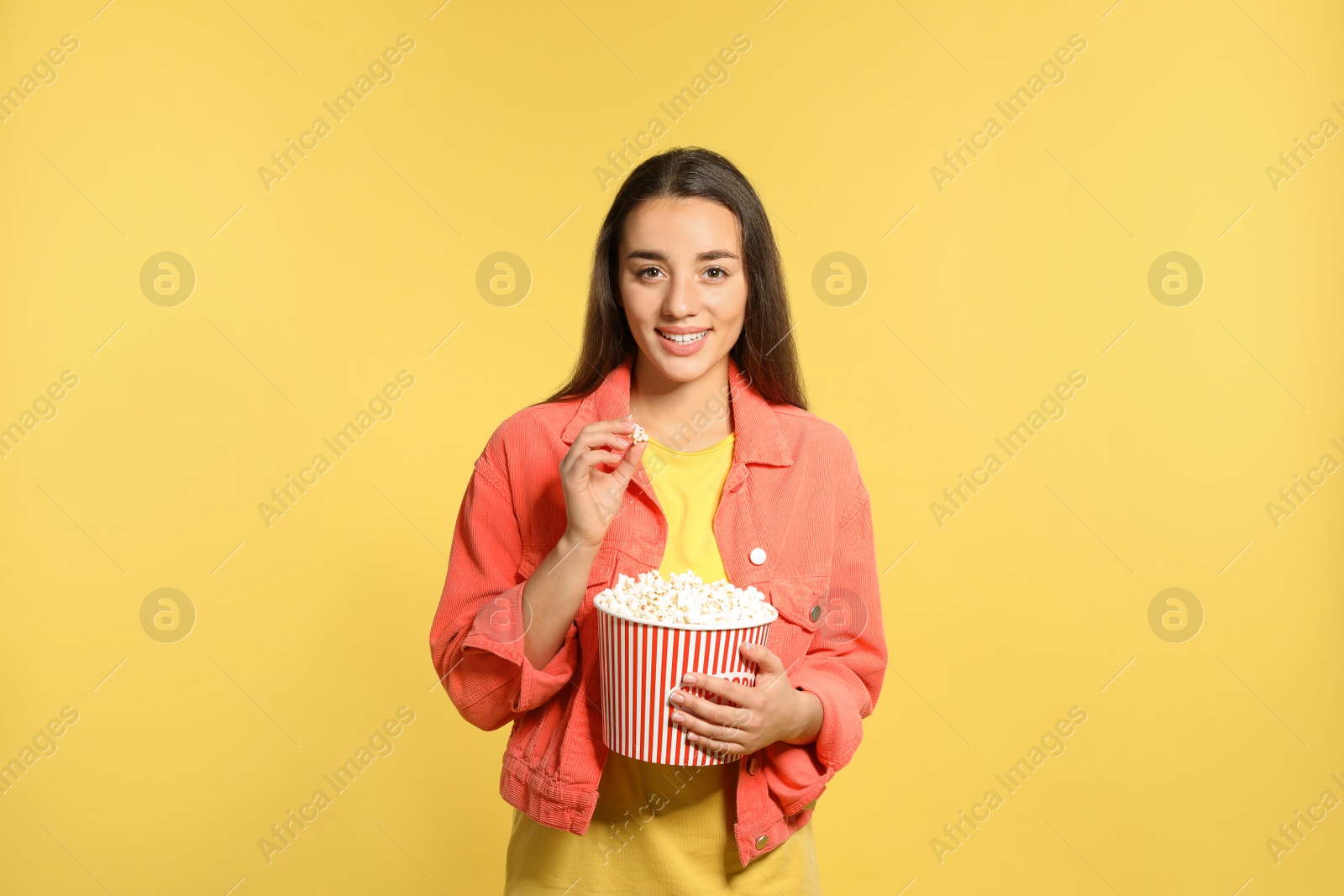 Photo of Woman with popcorn during cinema show on color background