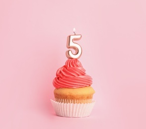 Photo of Birthday cupcake with number five candle on pink background