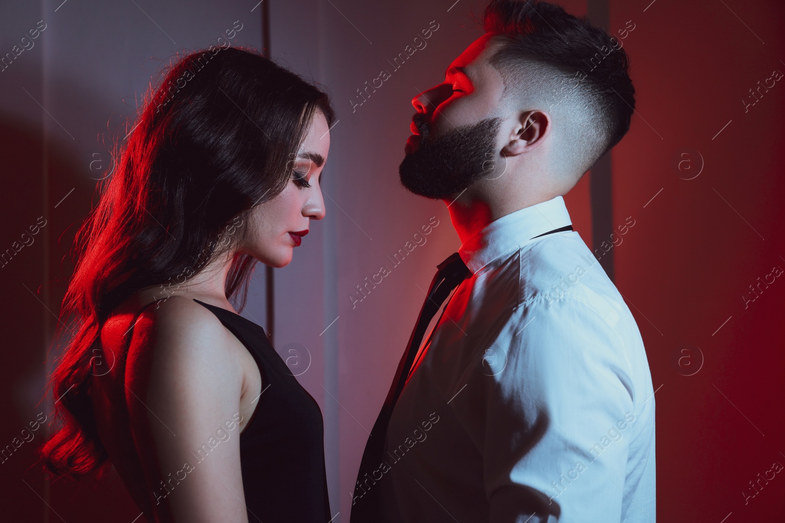 Photo of Handsome bearded man with sexy lady indoors. Color toned