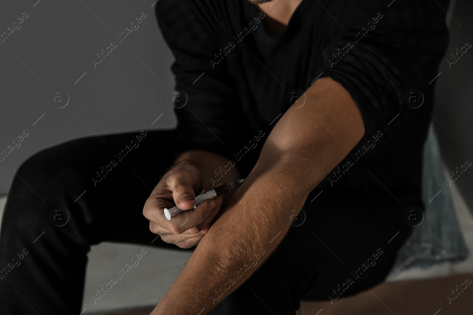 Photo of Male drug addict making injection, focus on hands