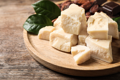 Photo of Organic cocoa butter on wooden table, closeup