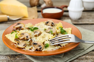 Delicious ravioli with mushrooms and cheese served on wooden table, closeup