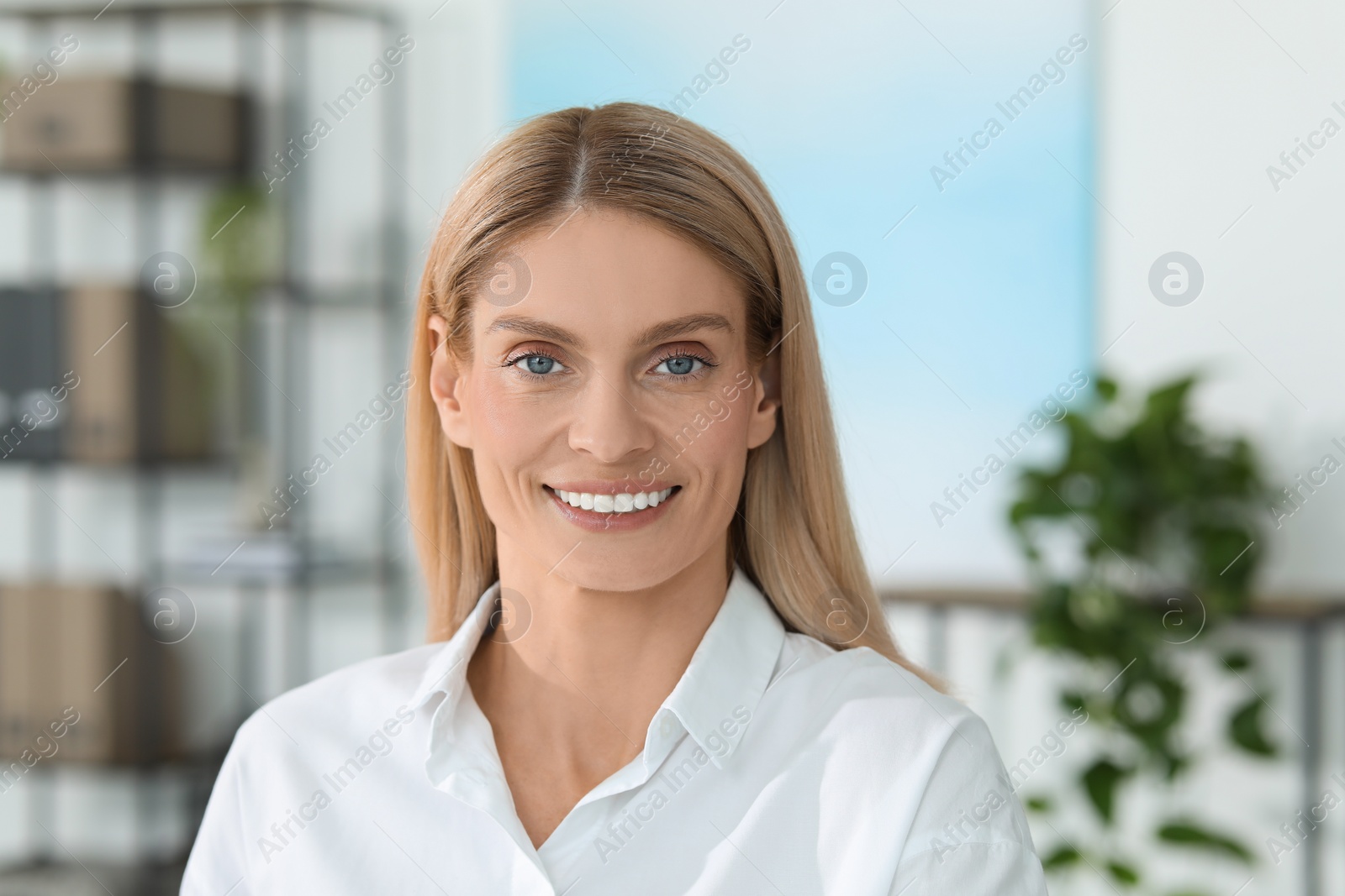 Photo of Portrait of smiling woman in formal clothes. Charming blonde lady posing indoors