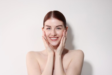 Portrait of smiling woman on light background