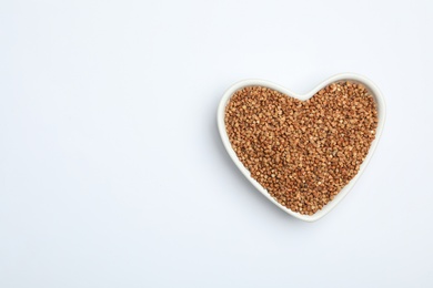 Buckwheat grains on white background, top view. Space for text