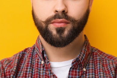 Photo of Handsome man with mustache on yellow background, closeup