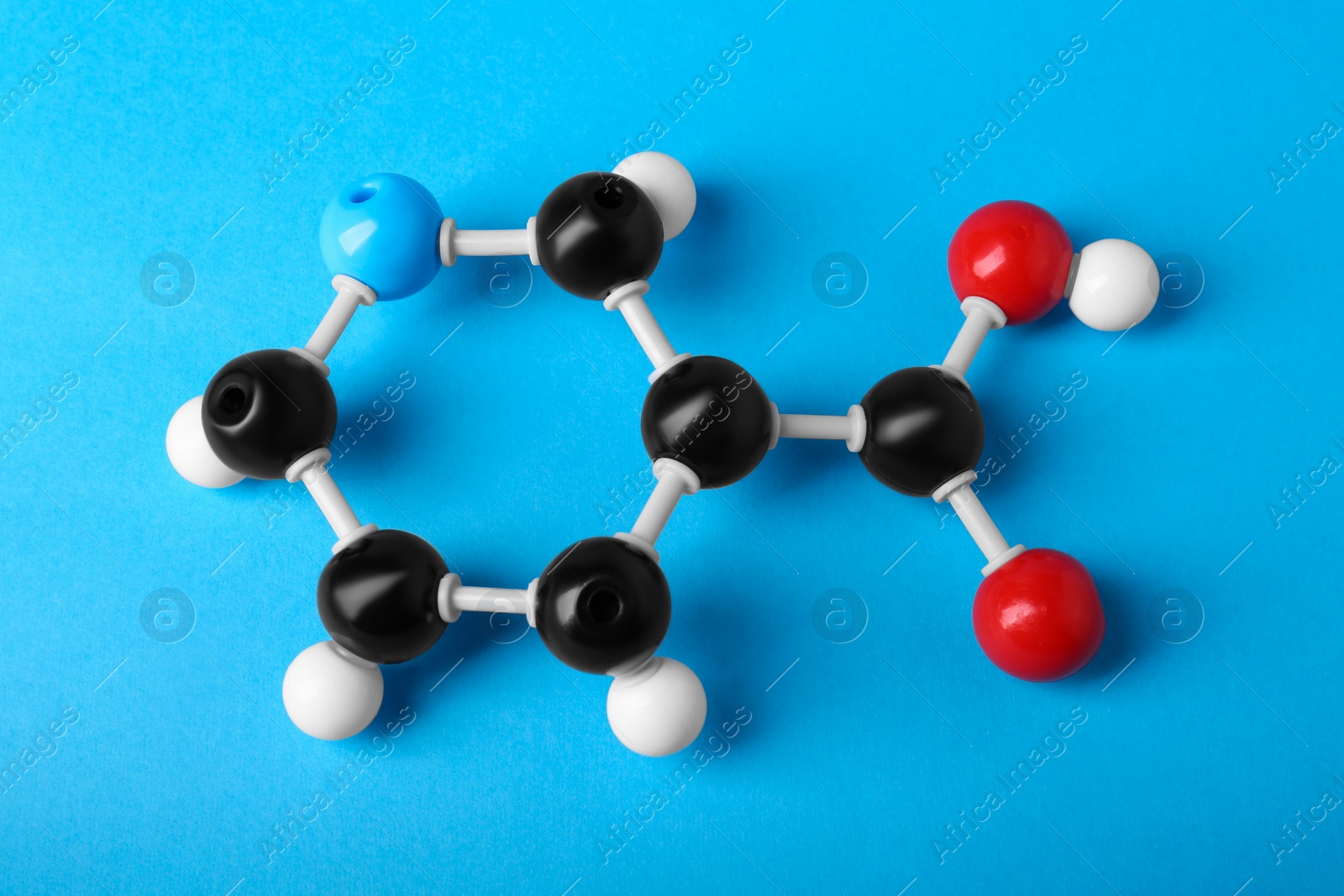 Photo of Molecule of vitamin B3 on light blue background, above view. Chemical model