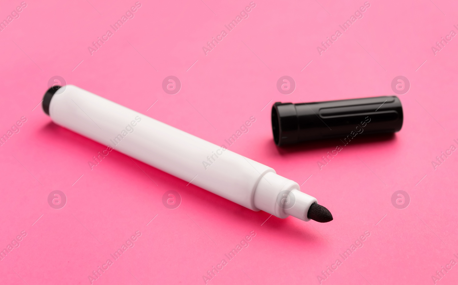 Photo of Black marker on pink background. School stationery