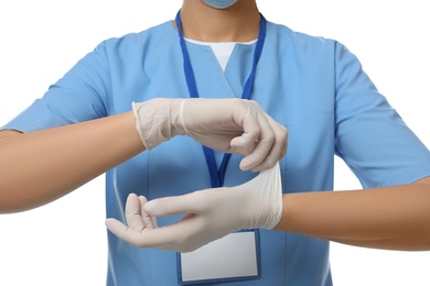 Doctor in scrubs putting on medical gloves against white background, closeup