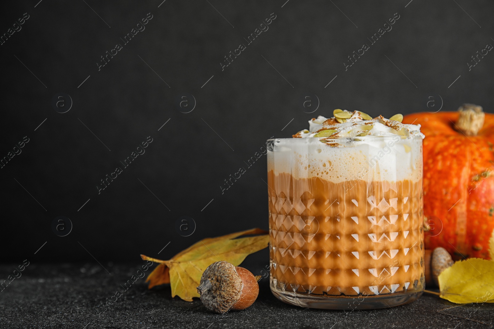 Photo of Composition with pumpkin spice latte in glass on table. Space for text