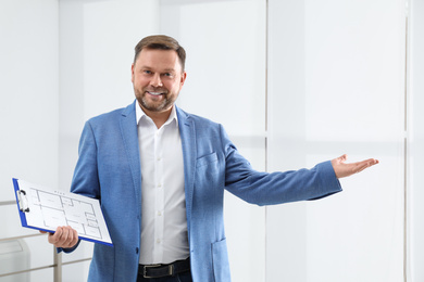 Photo of Male real estate agent with clipboard in new apartment
