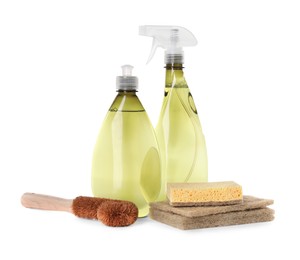 Bottles of cleaning product, brush and sponges isolated on white