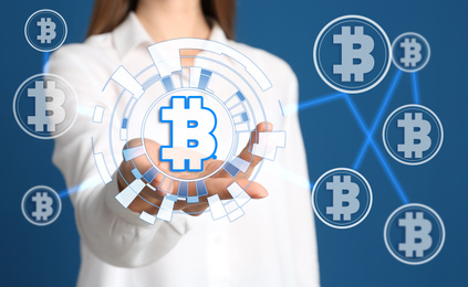 Fintech concept. Woman demonstrating scheme with bitcoin symbols