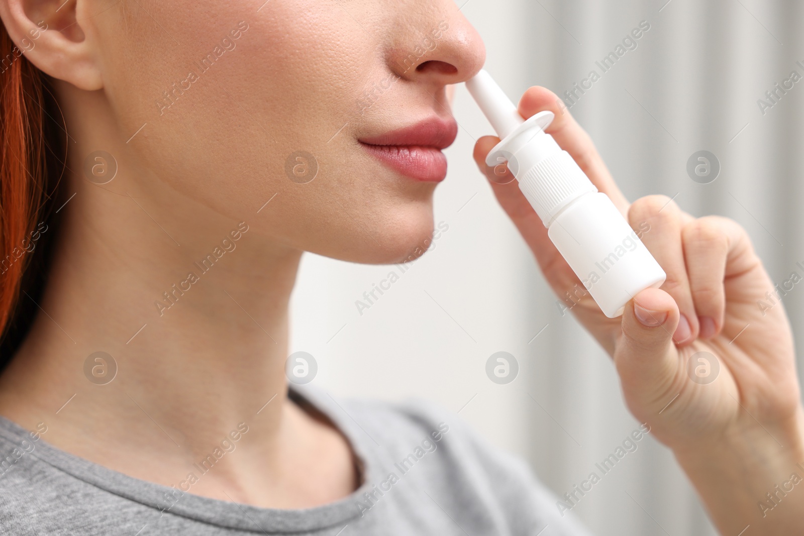 Photo of Medical drops. Woman using nasal spray at home, closeup