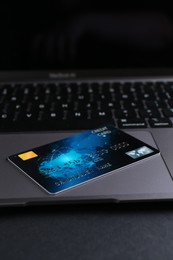 Photo of Laptop with credit card on grey table, closeup