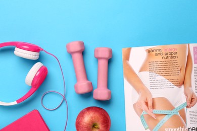 Flat lay composition with dumbbells on light blue background, space for text