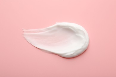 Photo of Sample of face cream on pink background, top view