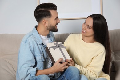 Photo of Lovely couple with beautiful gift at home