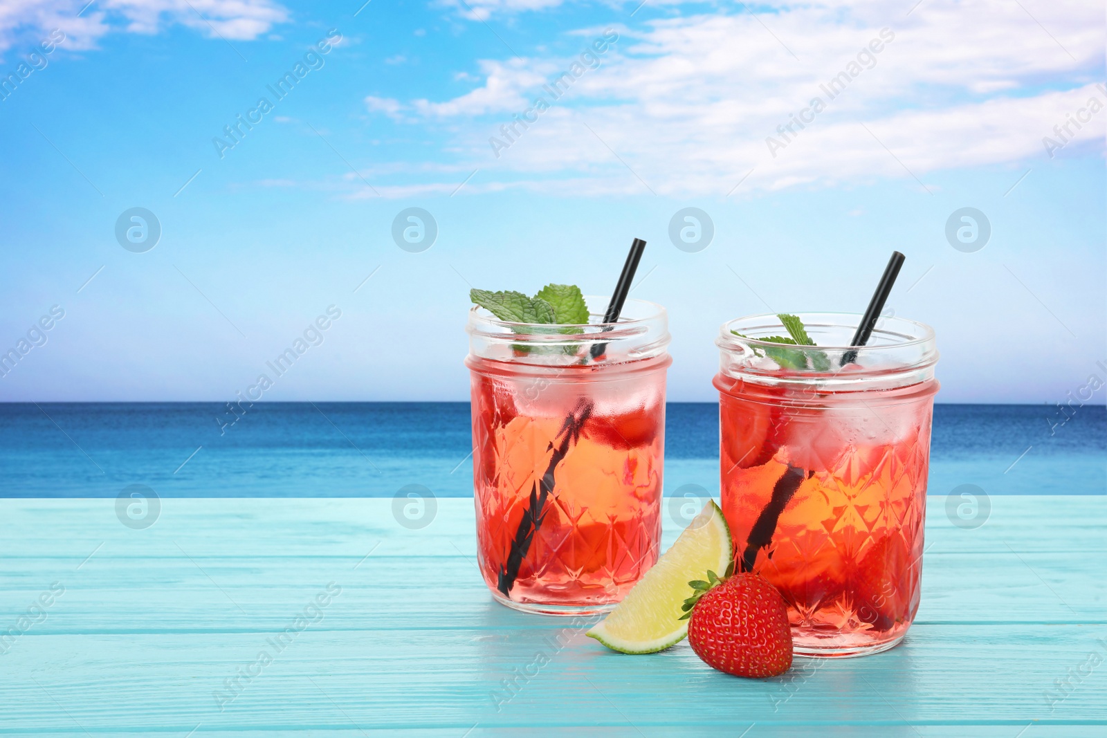 Image of Tasty refreshing drink on wooden table against sea