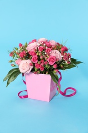 Photo of Beautiful bouquet of flowers in paper gift box on color background