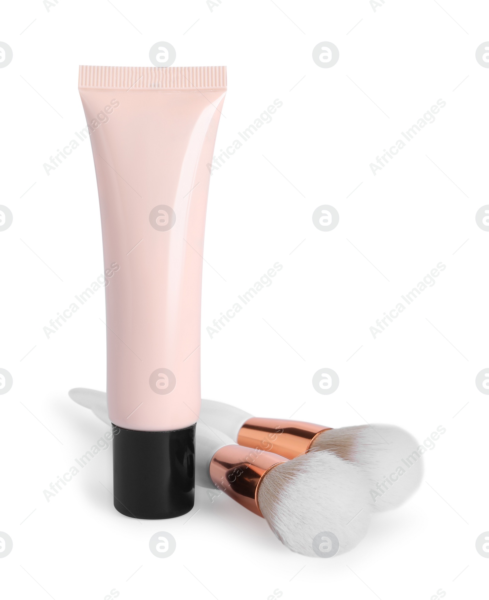 Photo of Tube of skin foundation and brushes on white background. Makeup product
