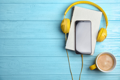 Photo of Books, coffee and mobile phone on light blue wooden table, flat lay. Space for text