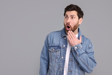 Photo of Portrait of surprised man on grey background, space for text