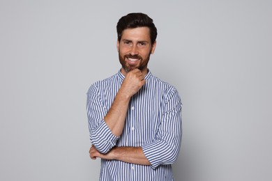Photo of Portrait of smiling bearded man on grey background