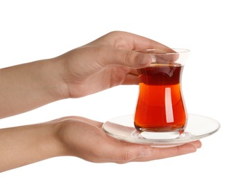 Photo of Woman holding glass of traditional Turkish tea with saucer on white background, closeup