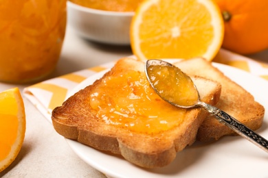 Photo of Delicious toasts with orange marmalade on table, closeup