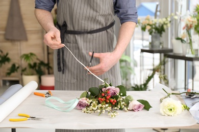 Male florist creating bouquet at workplace