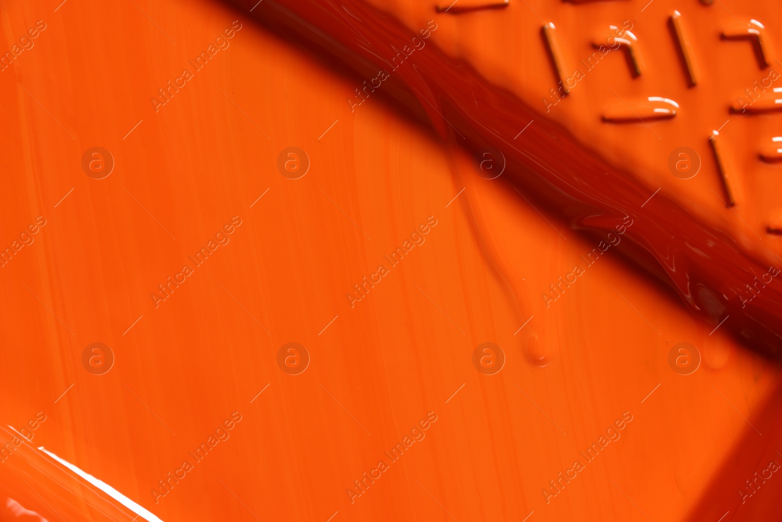 Photo of Tray with orange paint as background, top view