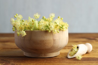 Fresh linden leaves and flowers on wooden table