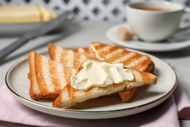 Photo of Tasty toasts with butter on light grey table, closeup