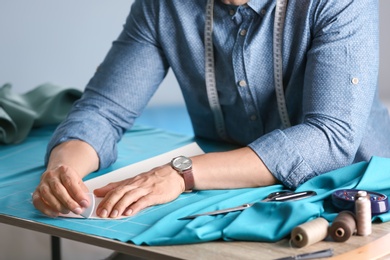 Tailor working at table in atelier, closeup