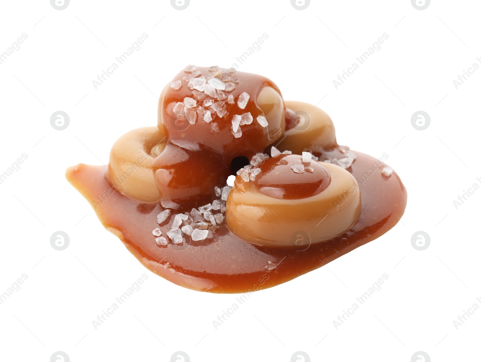Photo of Yummy candies with caramel sauce and sea salt isolated on white
