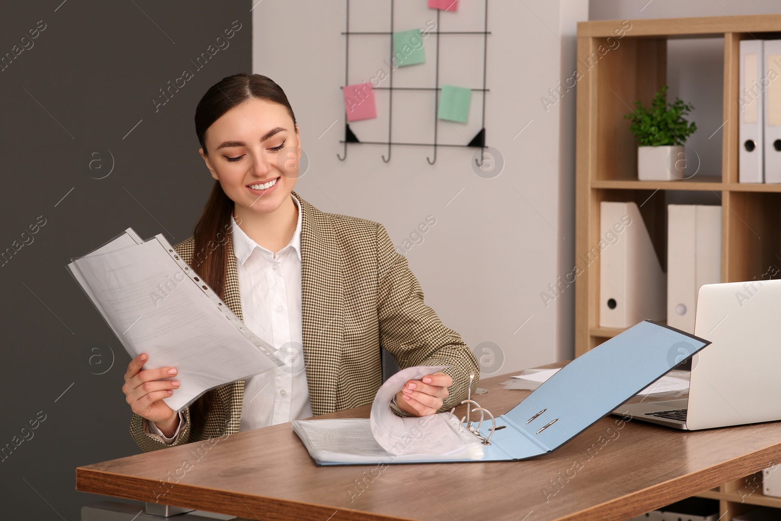 Photo of Businesswoman working with documents at wooden table in office